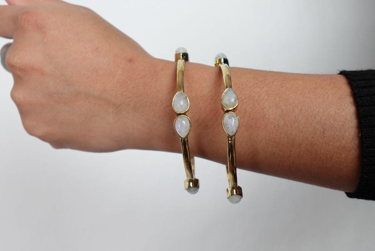 Teardrop Moonstone Brass Cuff - Sleek gold-tone brass cuff with teardrop moonstones in minimalist design.