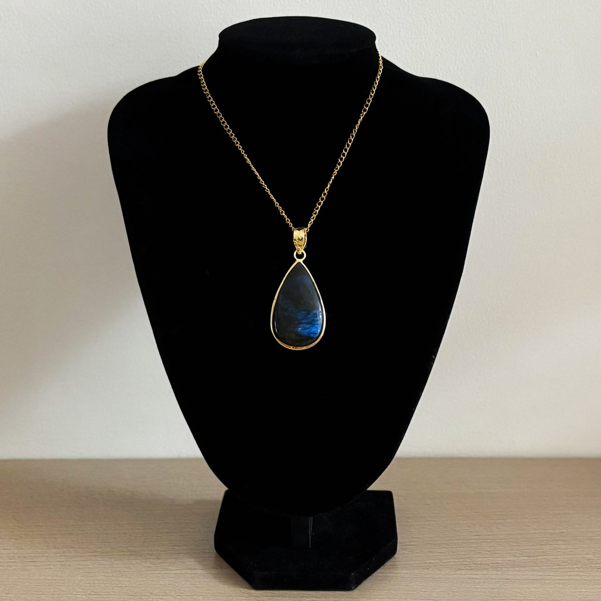 Teardrop labradorite pendant necklace on a bust, blue flash on a 44cm gold curb chain