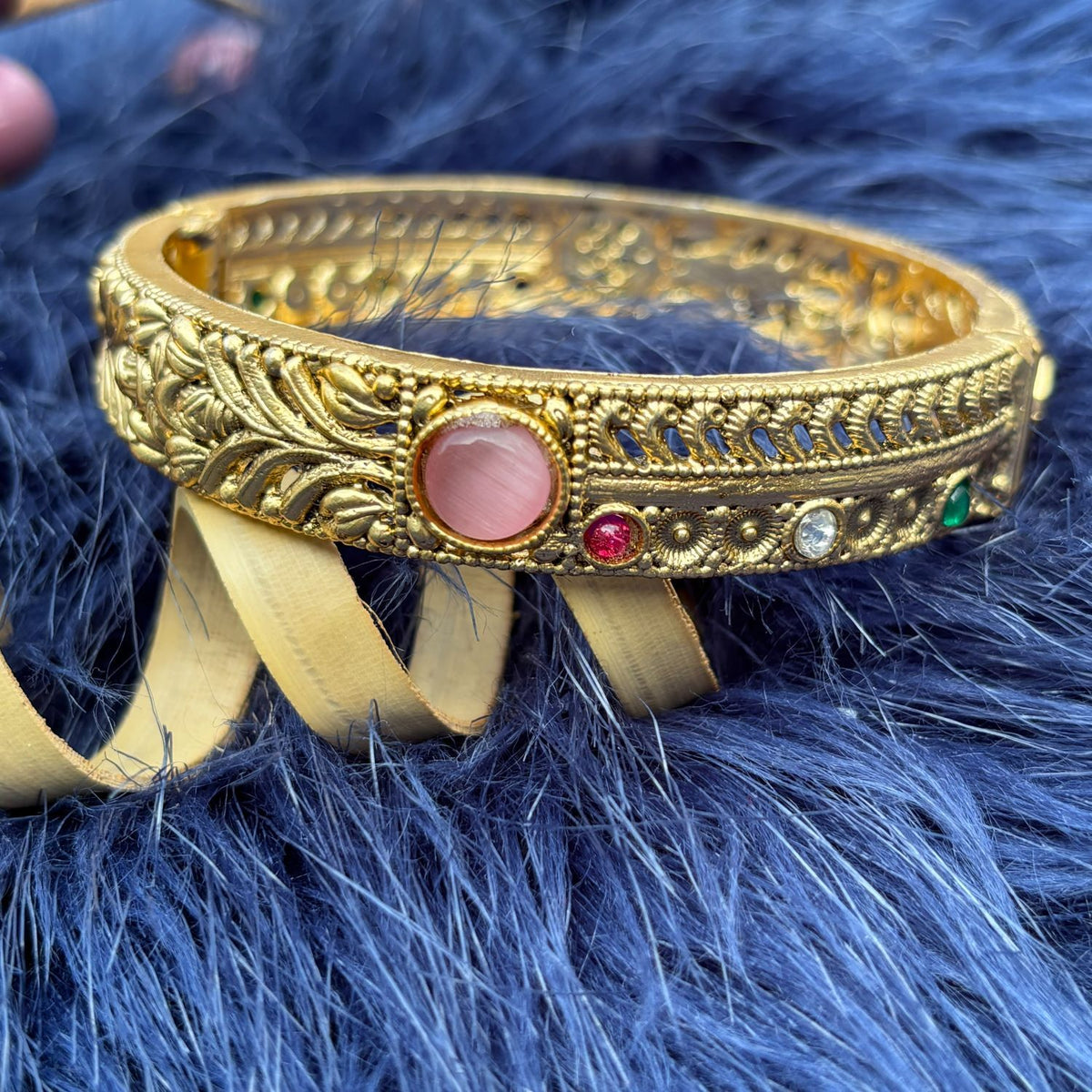 Close-up of shimmering pink cabochon and leaf-and-vine relief on Two-Way Brass Kada Bangle — Twin Dawn