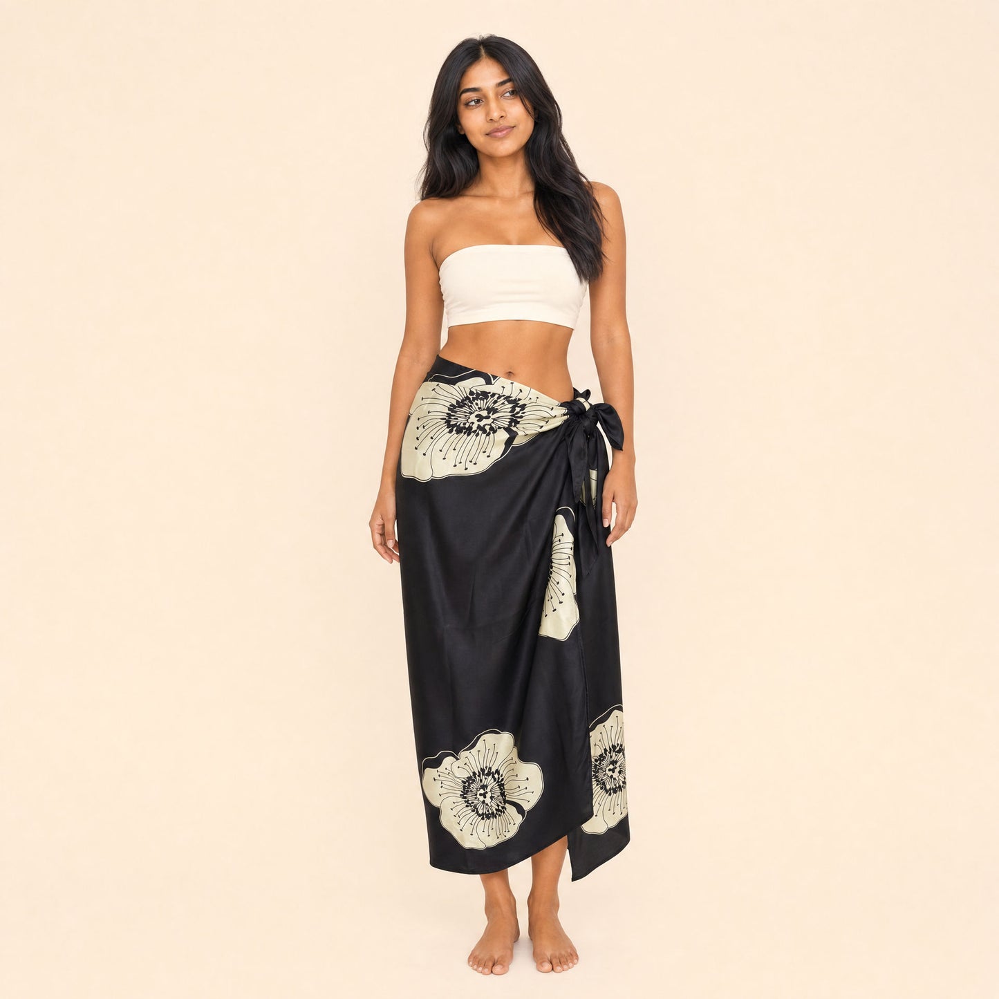 Black floral satin sarong by Boho Mantra, cream passion-flower blooms on black, worn as a side-tie wrap skirt